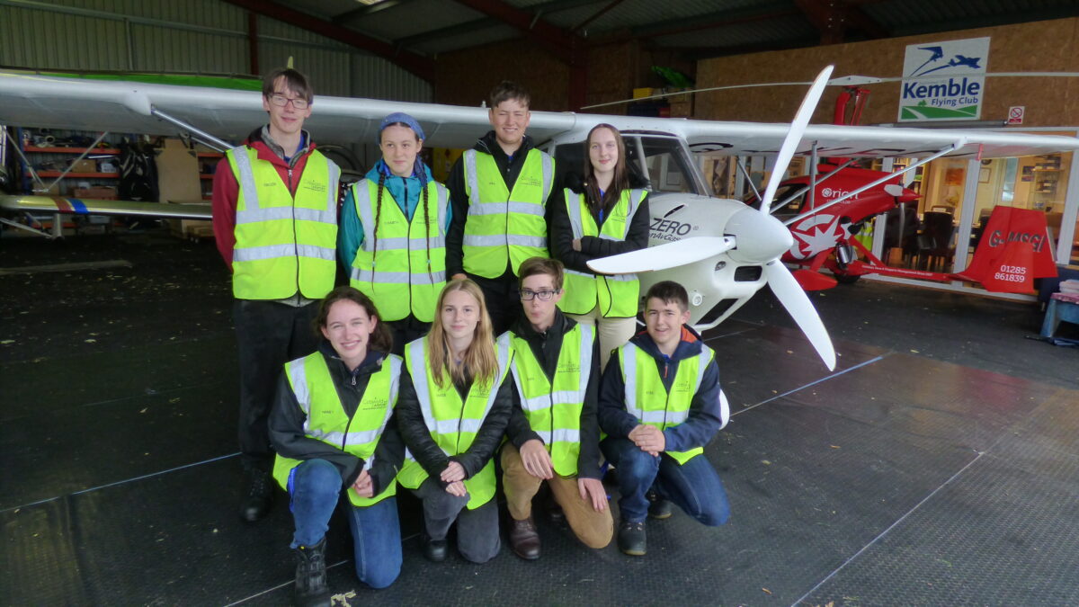 Cohort of 2023 Cotswold Airport Aviation scholars pose next to light aircraft.